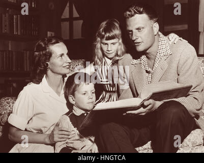 Evangelista Billy Graham la lettura da una famiglia la Bibbia con la moglie Ruth e i loro figli in Graham Montreat, North Carolina home nel 1957. Foto Stock