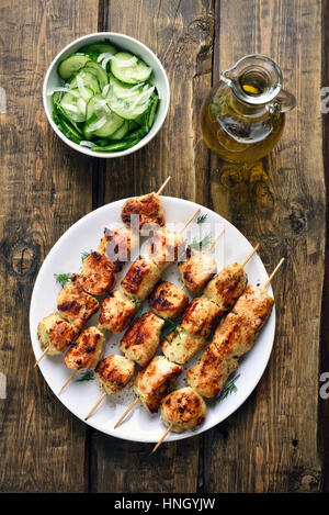 Spiedini di pollo e insalata di cetrioli, in stile country, vista dall'alto Foto Stock