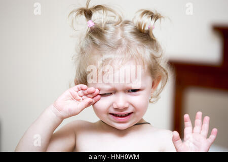 Ritratto di una ragazza triste bambino seduto su un letto in camera da letto. Kid svegliarsi nel letto infelice. Il tempo a letto Foto Stock