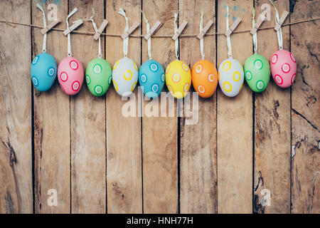 Coloratissimo uovo di pasqua appeso su uno sfondo di legno Foto Stock