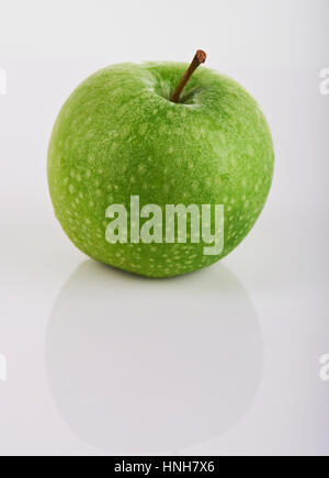 Un verde bagnato apple isolati su sfondo bianco Foto Stock