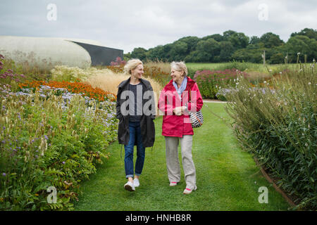 2 donne a piedi attorno a un giardino Foto Stock