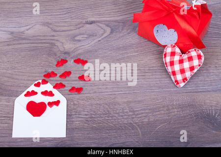Busta con cuori con un regalo su una base di legno Foto Stock