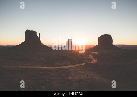 Visualizzazione classica di scenic Monument Valley con il famoso mezzoguanti e Merrick Butte in beautiful Golden. La luce del mattino al sorgere del sole in estate, Arizona, Stati Uniti d'America Foto Stock