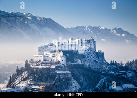 Visualizzazione classica della famosa Fortezza di Hohensalzburg nella storica città di Salisburgo in scenic. La luce del mattino al sorgere del sole su un bel sole freddo giorno d'inverno Foto Stock