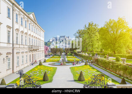 Visualizzazione classica dei Giardini Mirabell con la famosa fortezza di Hohensalzburg in background in una giornata di sole con cielo blu e nuvole in estate, Salisburgo Foto Stock