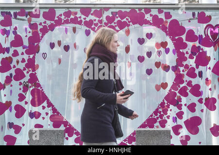 Londra, Regno Unito. Xiii Febbraio, 2017. Una donna cammina davanti a un gigantesco cuore adesivo un giorno prima del giorno di San Valentino il 14 febbraio Credito: amer ghazzal/Alamy Live News Foto Stock