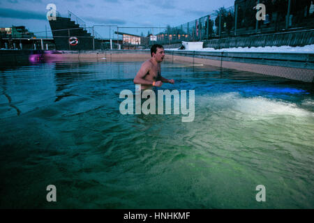 Danimarca, Copenaghen, 12 febbraio 2017. Piscina invernale i più temerari salta il ghiaccio acque del porto di Copenaghen pool come parte dell'evento "Ilddåb" durante l'arte danese e il festival di musica Frost Festival 2017 a Copenaghen. Nelle tenebre dell'inverno nuotatori furono incoraggiati a passare il coul acqua dal fuoco canoni illuminazione egli sky e fulmini interattiva in e al di fuori della piscina del porto. Credito: Gonzales foto/Alamy Live News Foto Stock