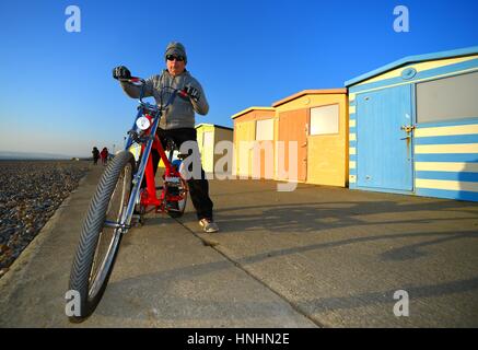 Seaford, East Sussex, Regno Unito. Xiii Febbraio, 2017. Regno Unito Meteo. Charlie godendo del sole di sera dopo una bellissima giornata di sole nel Sussex, cavalcando un American Schwinn custom Cruiser bike. Credito: Peter Cripps/Alamy Live News Foto Stock