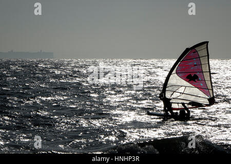 Beachlands, Hayling Island, Regno Unito. Il 13 febbraio 2017. Regno Unito Meteo. Soleggiato ma ventoso condizioni ha prevalso durante tutta la giornata sulla costa sud dell'Inghilterra. Un windsurf in difficoltà off Hayling Island in Hampshire. Credito: James jagger/Alamy Live News Foto Stock