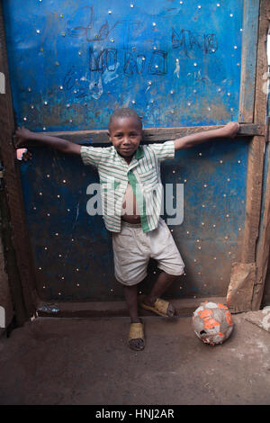 Ragazzo con un calcio in orfanotrofio, kibera baraccopoli, Nairobi, Kenya, Africa orientale Foto Stock