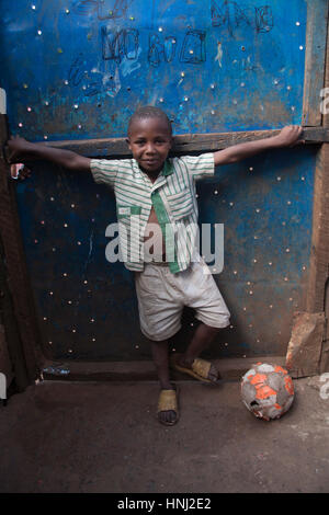 Ragazzo con un calcio in orfanotrofio, kibera baraccopoli, Nairobi, Kenya, Africa orientale Foto Stock