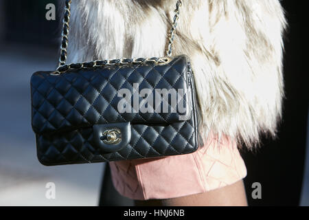 Donna con pelliccia bianca e rivestimento in pelle nera Borsa Chanel prima di Emporio Armani fashion show, la Settimana della Moda Milanese street style on gennaio Foto Stock