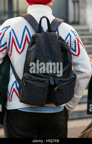 L'uomo con il maglione bianco con il blu e il rosso disegno prima di Salvatore Ferragamo fashion show, la Settimana della Moda Milanese street style nel gennaio 2017. Foto Stock