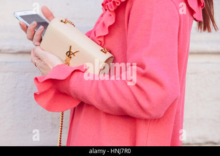 Donna con Yves Saint Laurent borsa beige e cappotto rosa prima di Etro fashion show, la Settimana della Moda Milanese street style on gennaio 16, 2017. Foto Stock