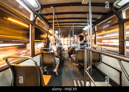 Interno di un Tram auto correre attraverso Hong Kong Island strade di notte. Ampio angolo e una lunga esposizione sono utilizzati. Foto Stock