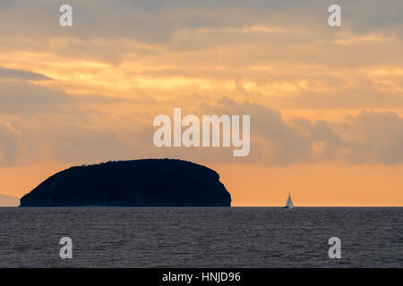 Tramonto dietro Steep Holm isola nel Canale di Bristol, con yacht spettacolare Cielo e nubi visto da Weston-super-Mare nel Somerset, Regno Unito Foto Stock