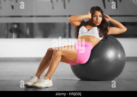 Lavorando con sfera di aerobica i giovani ispanici latina ragazza in bianco e nero i colori di sfondo della palestra Foto Stock