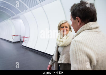 Coppia senior in abbigliamento invernale nel corridoio della metropolitana Foto Stock