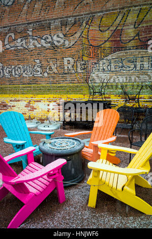 Colorate sedie per esterni e colorata carta murale in neve sul patio della Cantina Boathouse Restaurant; Salida; Colorado: STATI UNITI Foto Stock