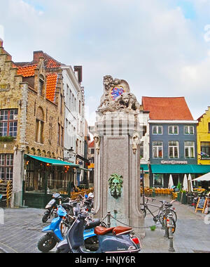 BRUGES, Belgio - 26 Maggio 2011: la fontana con Lion e recare all'Eiermarkt Square, piena di caffetterie accoglienti e bar, il 26 maggio in Bruges. Foto Stock