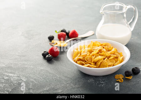 Cornflake cereali in una ciotola con il latte su sfondo blu, colazione veloce Foto Stock