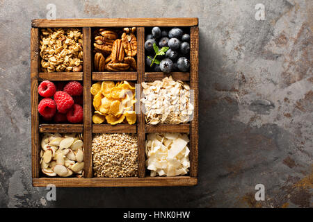 Colazione alimenti, avena, cereali e frutta in una scatola di legno overhead shot Foto Stock