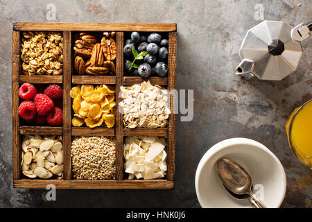 Colazione alimenti, avena, cereali e frutta in una scatola di legno overhead shot Foto Stock