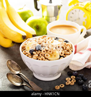 Freddo salutare a base di cereali con banana e mirtillo in una ciotola bianco, veloce colazione o merenda per bambini con copyspace Foto Stock