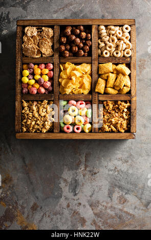 Varietà di cereali freddi in una scatola di legno, veloce colazione per bambini overhead shot Foto Stock