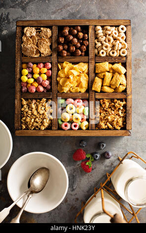 Varietà di cereali freddi in una scatola di legno, veloce colazione per bambini overhead shot Foto Stock