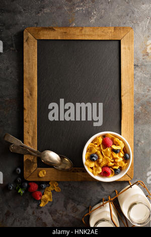 Una sana cornflakes con lampone e mirtillo in una ciotola, veloce colazione o uno spuntino overhead shot Foto Stock