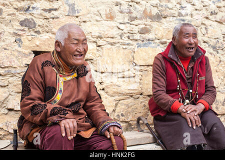 Tibetani Khampa uomini e donne pregare nel corso di una cerimonia presso il Convento delle Monache Tagong, alta nell'altopiano tibetano, Sichuan, in Cina Foto Stock