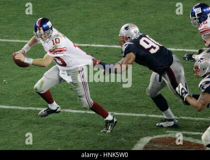 New York Giants di Eli Manning, sinistra, viene afferrato dal New England Patriots Rashad Moore nel quarto trimestre al Super Bowl XXLII in Glendale, AZ, domenica 3 febbraio, 2008. Foto di Francesco Specker Foto Stock