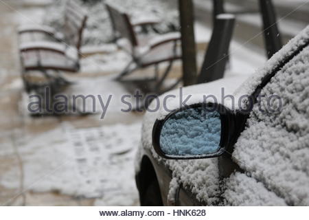 Un specchio auto e posti a sedere coperti di neve dopo un inverno pesante nevicata nel centro cittadino di Budapest, Ungheria Foto Stock