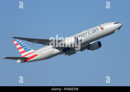 American Airlines Boeing 777-223ER N773un decollo dall'Aeroporto di Londra Heathrow in cielo blu Foto Stock