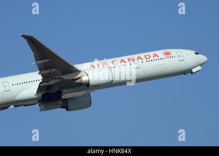 Air Canada Boeing 777-333ER il decollo dall'Aeroporto di Londra Heathrow in cielo blu Foto Stock