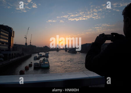 Il sole sorge dietro il Tower Bridge di Londra. Foto Stock
