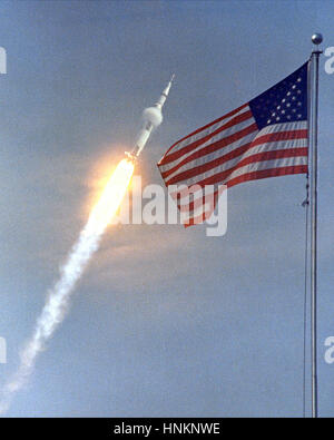 La bandiera americana annunciava il lancio di Apollo 11, il primo atterraggio lunare di missione, il 16 luglio 1969. La massiccia Saturn V rocket sollevati dalla NASA il Kennedy Space Center con gli astronauti Neil A. Armstrong, Michael Collins e Edwin "Buzz" Aldrin al 9:32 a.m. EDT. Quattro giorni più tardi, il 20 luglio, Armstrong e Aldrin sbarcati sulla superficie della luna mentre Collins orbitavano overhead in il modulo di comando. Armstrong e Aldrin raccolti campioni di materiale lunare e distribuito esperimenti scientifici che ha trasmesso i dati circa l'ambiente lunare. Credito di immagine: la NASA Foto Stock