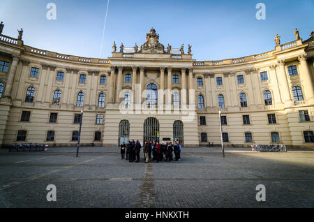 Un gruppo di turisti in Bebelplatz al di fuori della Facoltà di Diritto / Juristische Fakultät / Alte Bibliothek, Berlino, Germania Foto Stock