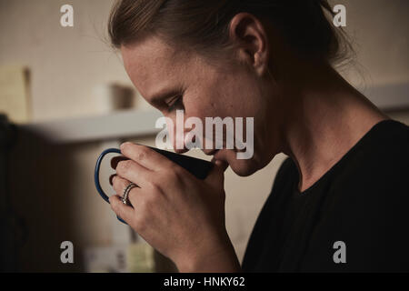 Donna che mantiene un fresco bicchiere di infuso di caffè per il suo naso. Foto Stock