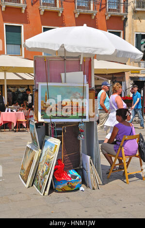 Venditore ambulante che mostra la sua arte in vendita lungo il porto di Venezia, Italia Foto Stock