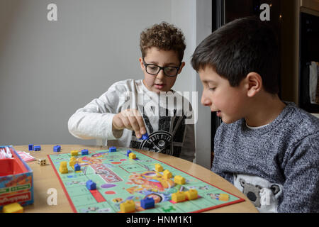 Ragazzi, età 9-10 anni, giocando a monopolistico gioco da tavolo Foto Stock