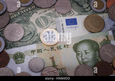 British pound coin sullo sfondo delle valute comprese yuan, dollaro ed euro Foto Stock