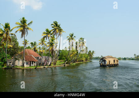 India, alberi di cocco e di riflessione beautifoull house boat sul retro acque del Kerala Foto Stock