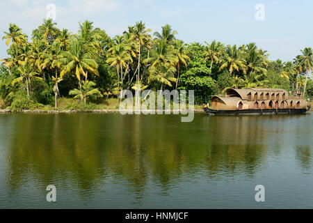 India, alberi di cocco e di riflessione beautifoull house boat sul retro acque del Kerala Foto Stock