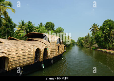 India, alberi di cocco e di riflessione beautifoull house boat sul retro acque del Kerala Foto Stock