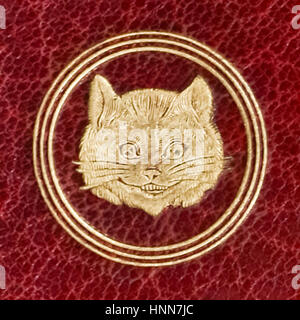 Close-up del Cheshire cat in rilievo sul retro di copertina di un borgogna Marocco cuoio edizione di "Alice nel paese delle meraviglie" da Lewis Carroll (1832-1898), pubblicato nel 1865. Foto Stock