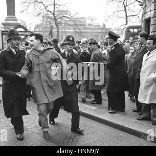 Un uomo è scortato via dalla polizia in Trafalgar Square, Londra, dove vi era un contatore-dimostrazione nel corso di una riunione organizzata da anti-apartheid i sostenitori di oggi. Un autocarro telonato, un piccolo furgone e una vettura privata, il cuscinetto poster dicendo "Non osley Mau Mau' fermato vicino a South Africa House. La vettura e van sono stati azionati off sulle istruzioni di polizia ma una rissa avviata mentre gli uomini sono stati rimossi dal camion. Foto Stock