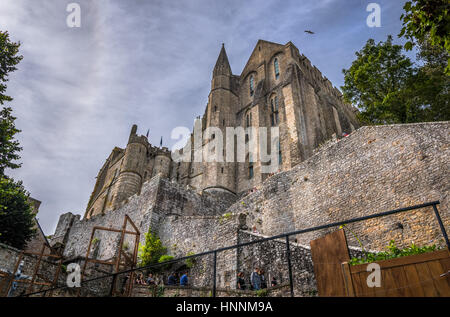 Vista dal basso sui muri di pietra e Mont Saint Michel abbey, Normandia Francia Foto Stock